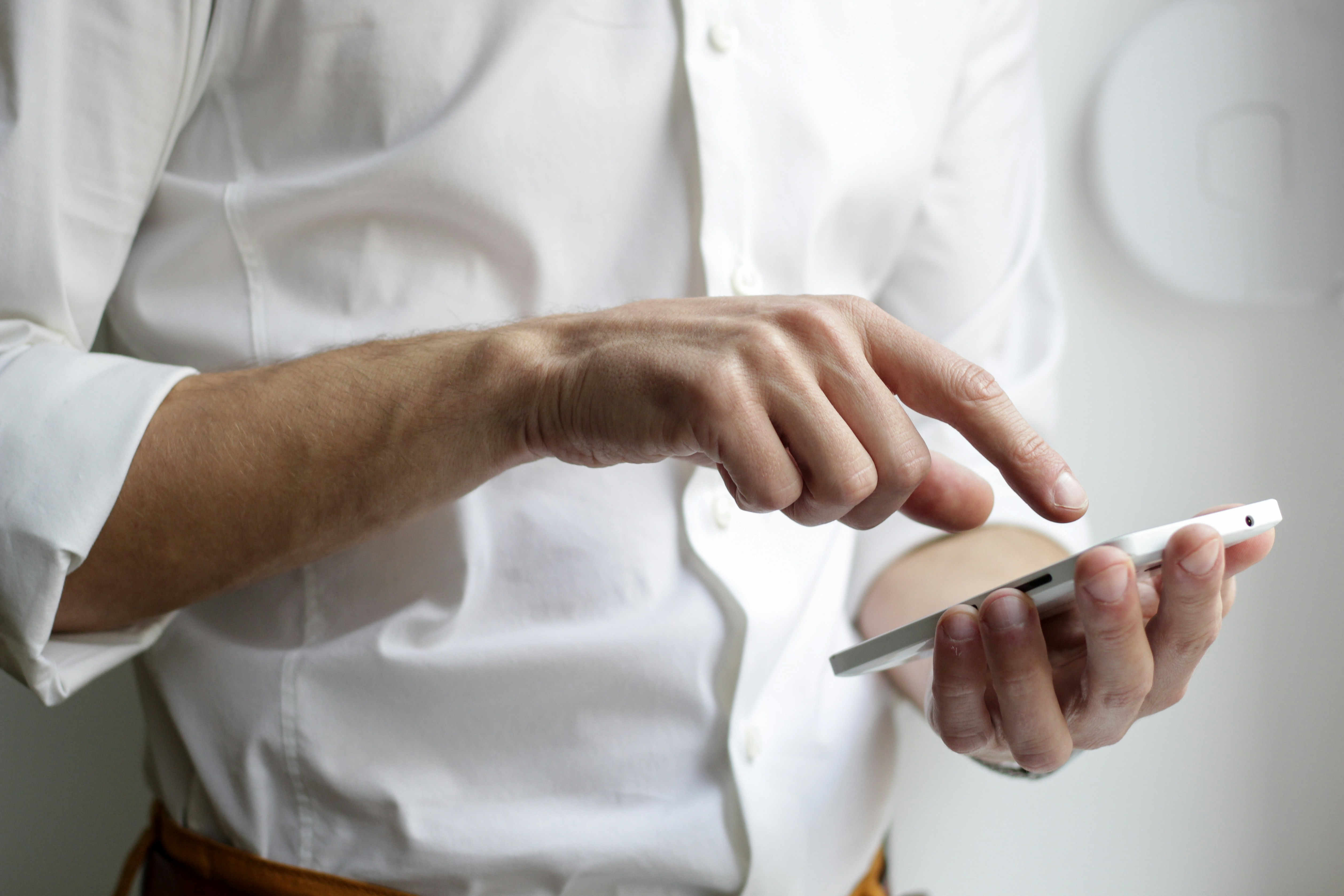 Person with white shirt tipping on phone