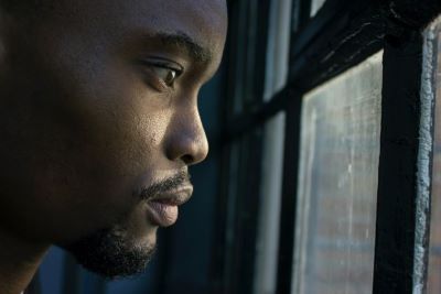 Black man looking out window