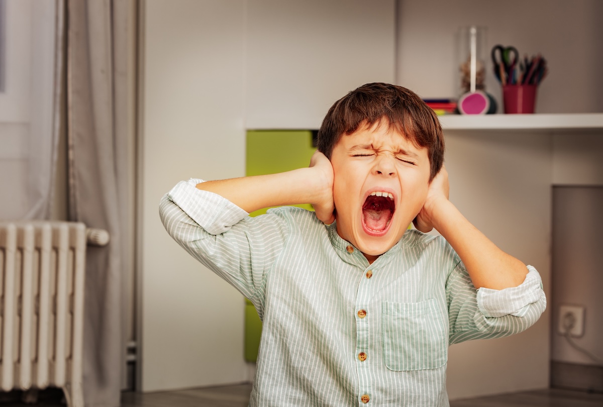 screaming-autistic-child Little autistic boy with strong negative face expression closing ears and loudly screams
