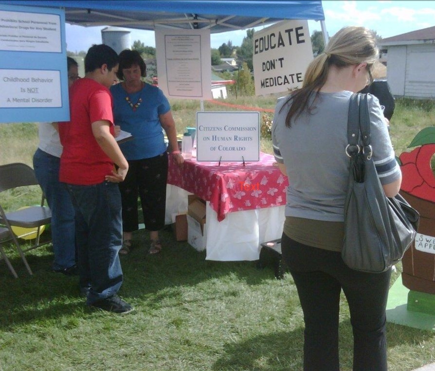 CCHR CO booth with people looking at printed materials